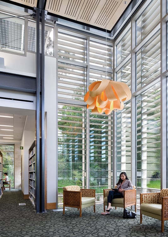 LZF wooden lamp in white illuminates a reading area in a library in the USA