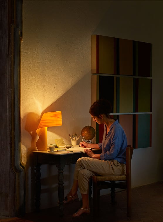 Wooden lamp in yellow color illuminated on the table of a desk