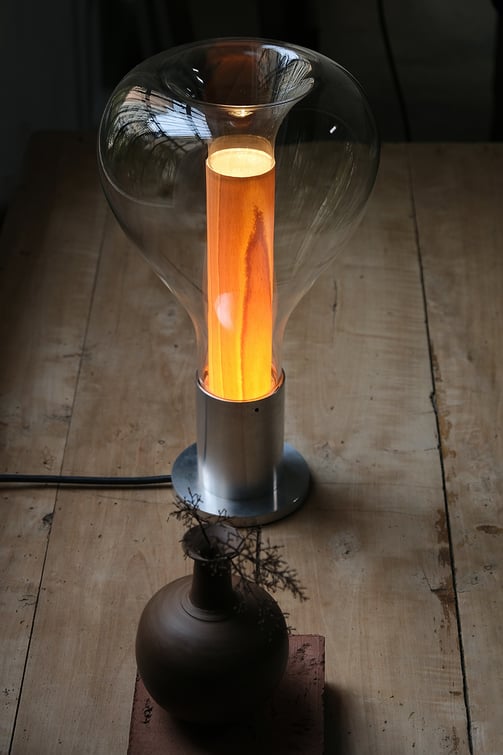 Detail of wooden table lamp illuminated by reflecting light through glass