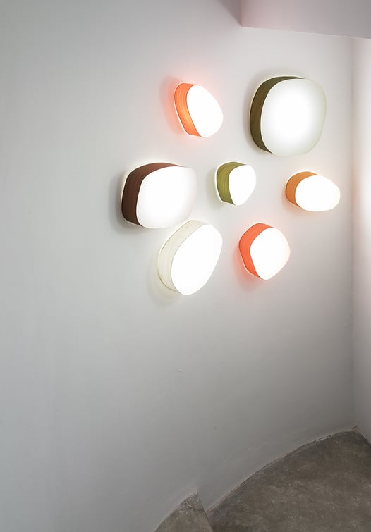 Wooden lamps in the shape of pebble decorating the wall of a staircase