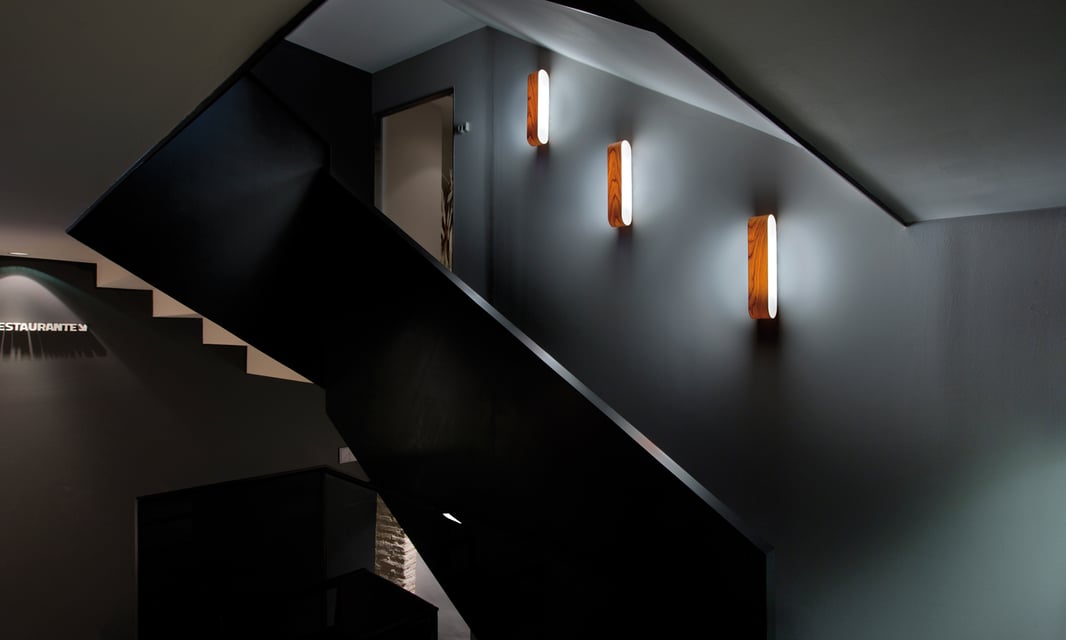 Cherry wood wall lamps lighting up a staircase in a hotel