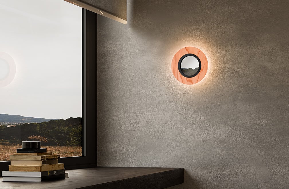 Circular wall lamp diffusing light all around with a central mirror in an office