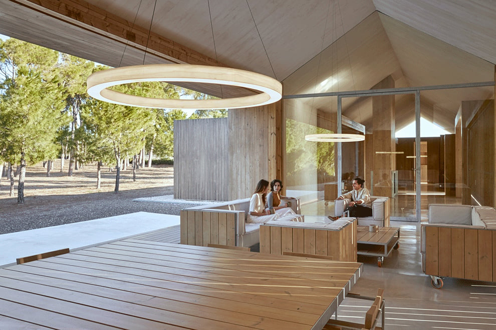 House with open space with ring shaped lamps made of wood veneer and light diffuser