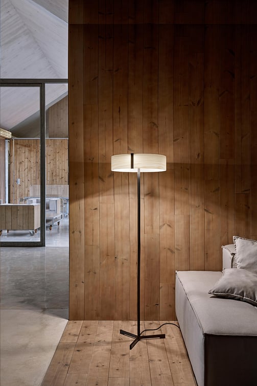 Modern floor lamp with metal base and LED lighting diffused through natural veneer wood