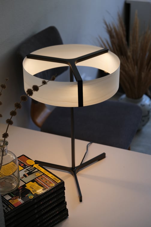 Detail of table lamp with metal base and natural veneer diffuser with minimalist shape and clean lines