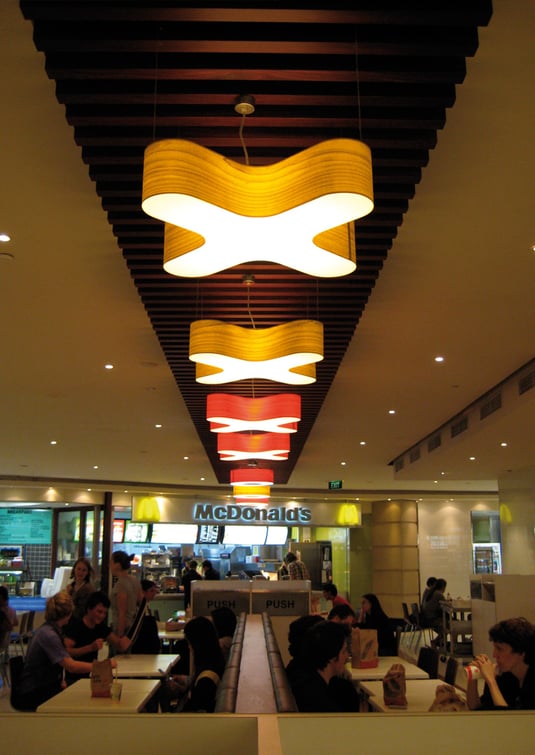 Lamps made of wood veneer and in the shape of an X in the restaurant area of a shopping centre