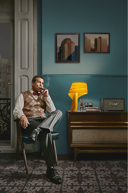 Nelson smoking a cigar on his armchair. LZF Air table lamp.
