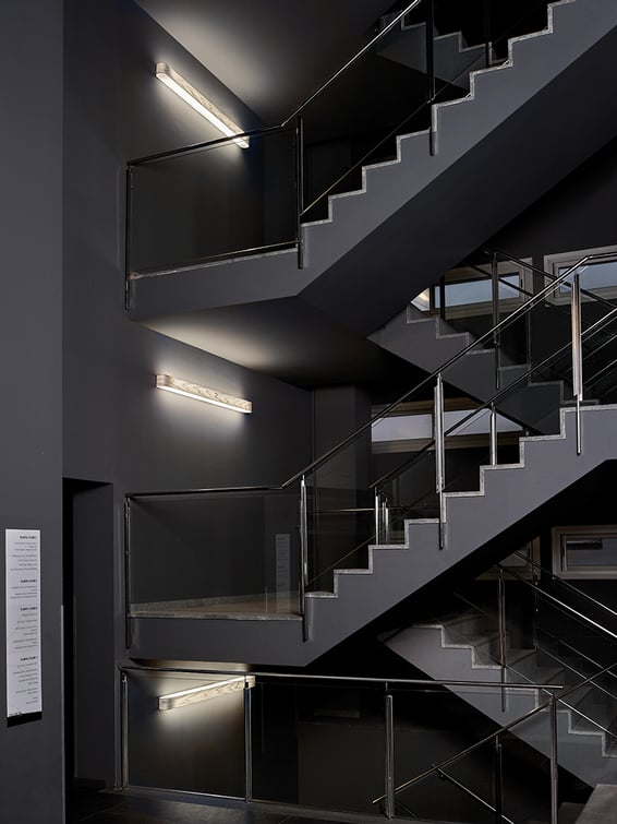 Open staircases-of-a-hotel-with-LZF-wall-lamps-in-grey-wood