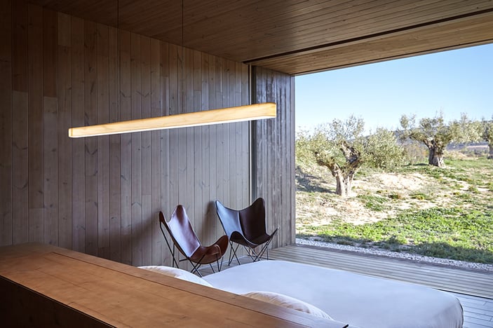 Slim linear-wooden-lamp-over-a-bedroom-headboard