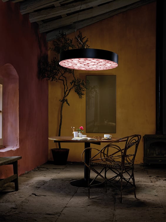 Reading area-with-circular-suspension-lamp-with-black-frame-and-interior-of-irregular-spirals-of-wood-veneer-in-pink-color