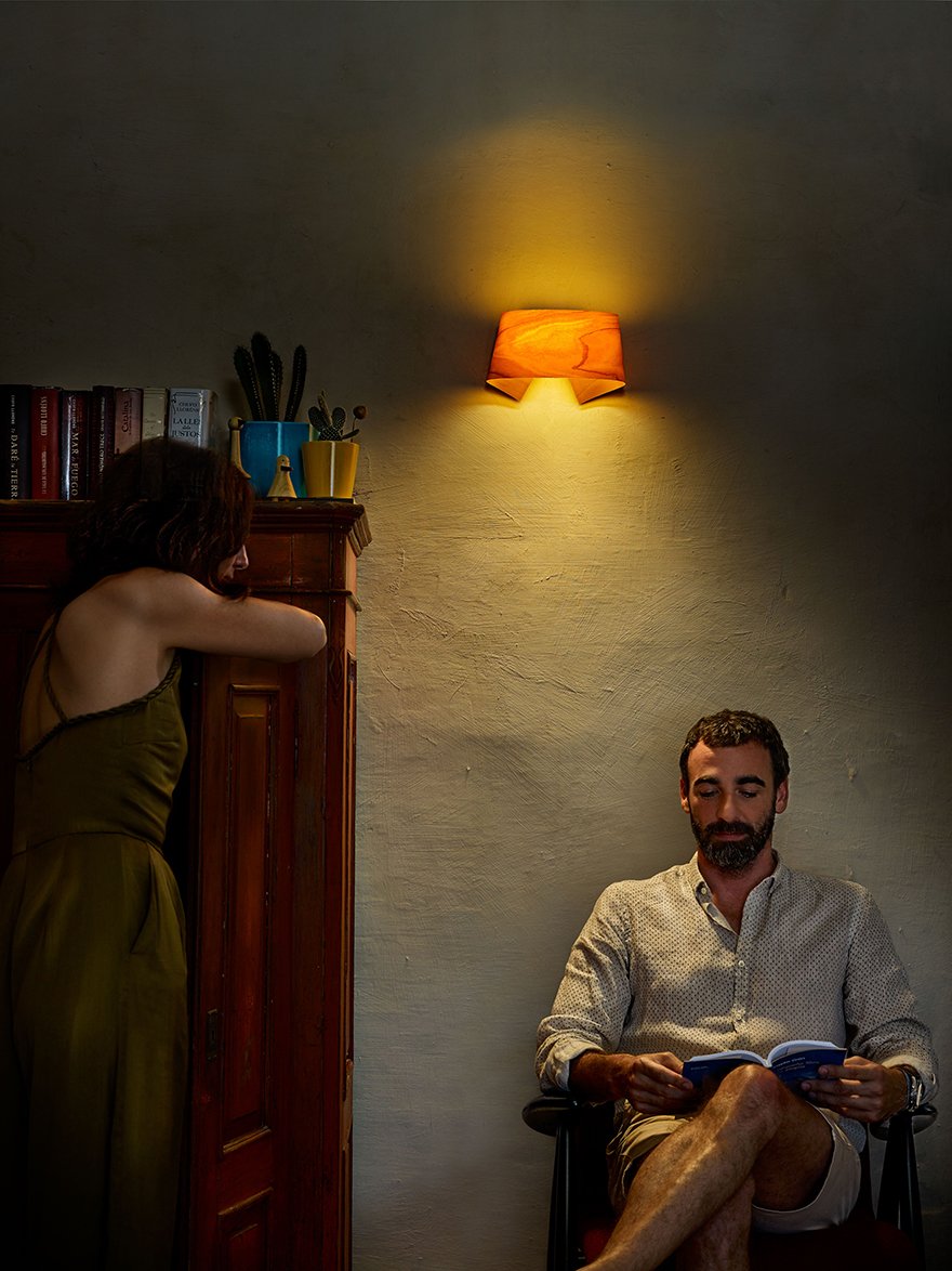 Man reading-by-the-light-of-a-yellow-wooden-wall-lamp-by-LZF