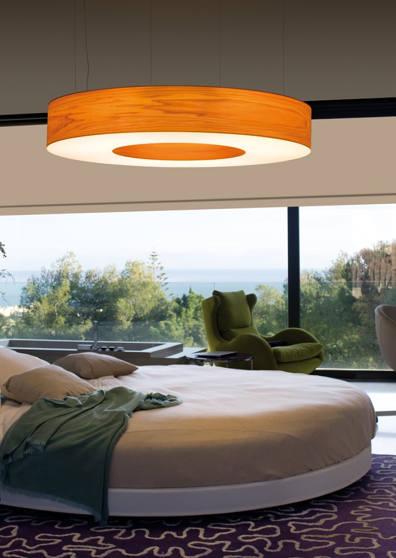 Bedroom with-round-bed-illuminated-with-large-cherry-wood-veneer-ring-shaped-lamp